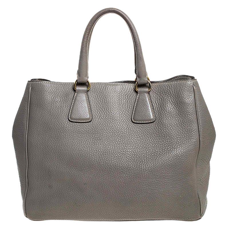 Feel great every time you walk out the door with this well-made leather bag. With the interior lined in nylon, this bag is spacious and stylish. This admirable Prada tote in grey is hed by two handles and finished with the brand name on the