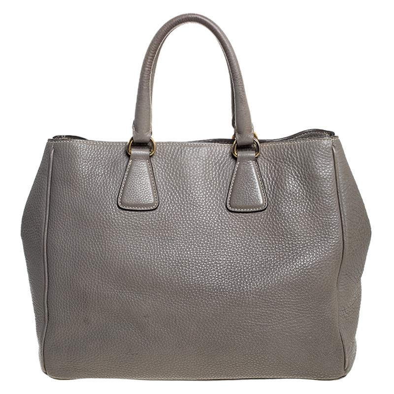 Feel great every time you walk out the door with this well-made leather bag. With the interior lined in nylon, this bag is spacious and stylish. This admirable Prada tote in grey is hed by two handles and finished with the brand name on the front.

