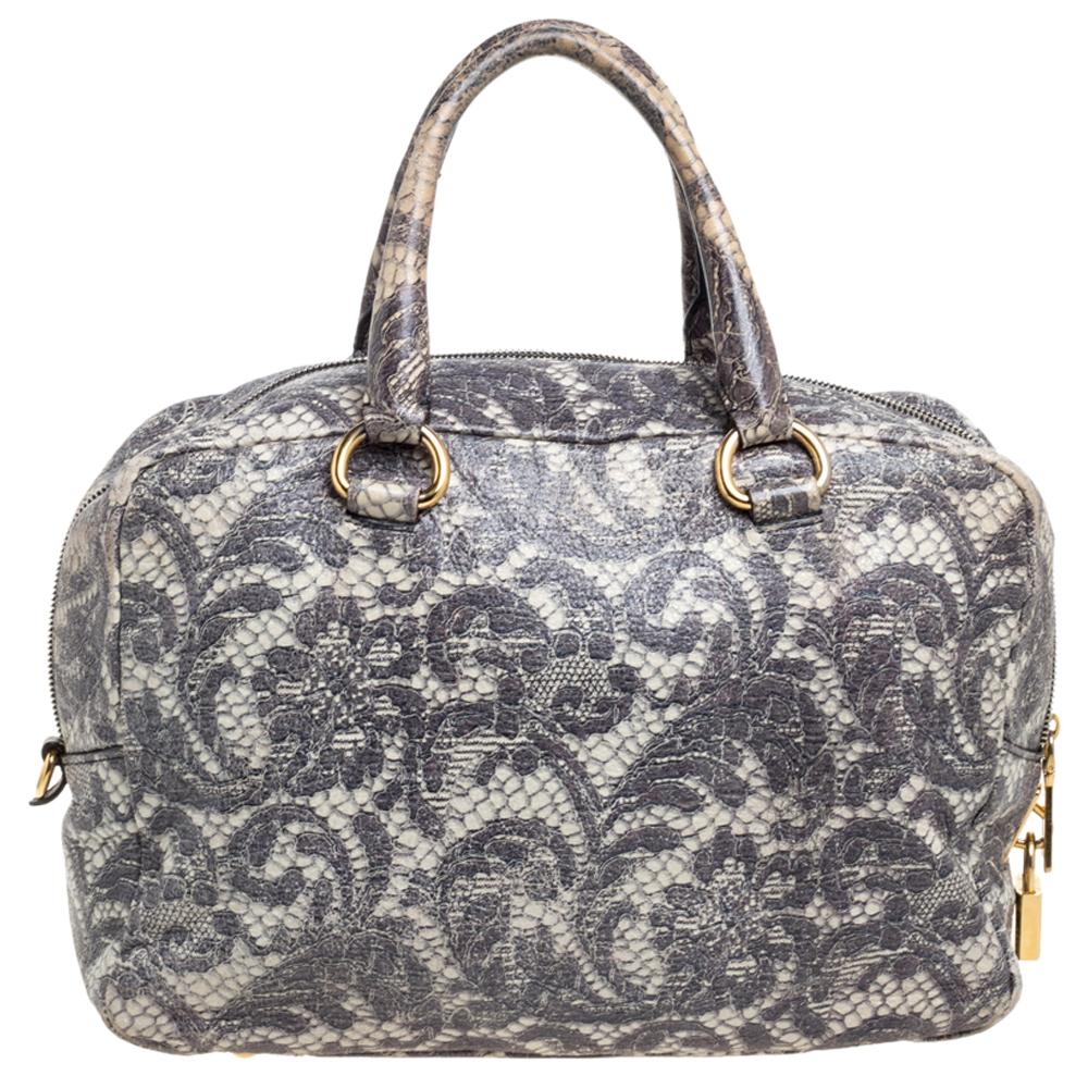 When you carry this Prada creation, be ready to catch admiring glances as this bag is stylish and handy. The bag has been crafted from leather designed with a lace print all over as well as two top handles. The top zip closure opens to a