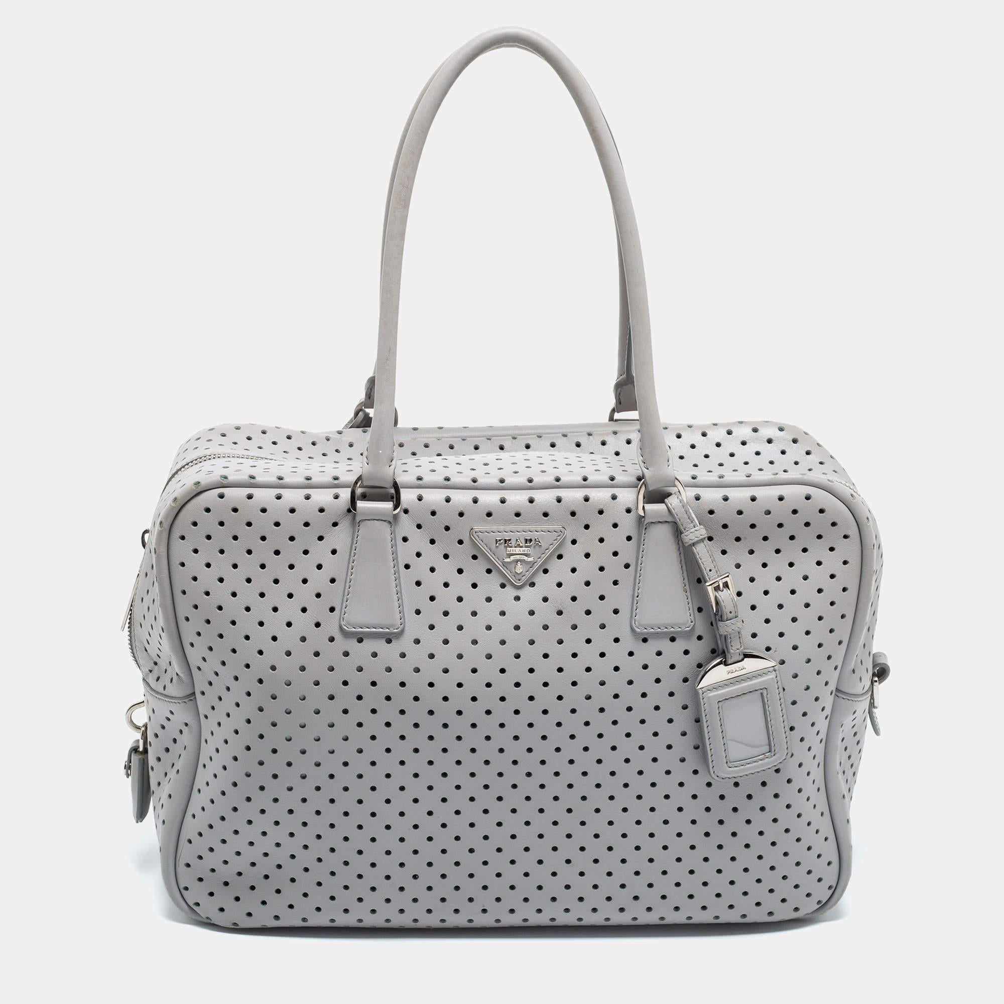 Experience fine craftsmanship with this immaculately designed Prada leather bag. It has two handles, a front logo, and a perforated exterior.

Includes: Original Dustbag, Detachable Pouch, Padlock & Key

