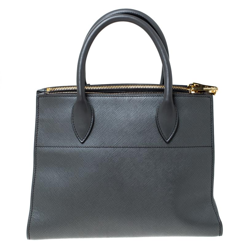 This bag by Prada is a lovely companion for a fashionable woman. This leather bag is brilliantly fashioned and spaciously sized. The Saffiano leather used in this bag assures long durability while the brand name on the front adds a signature