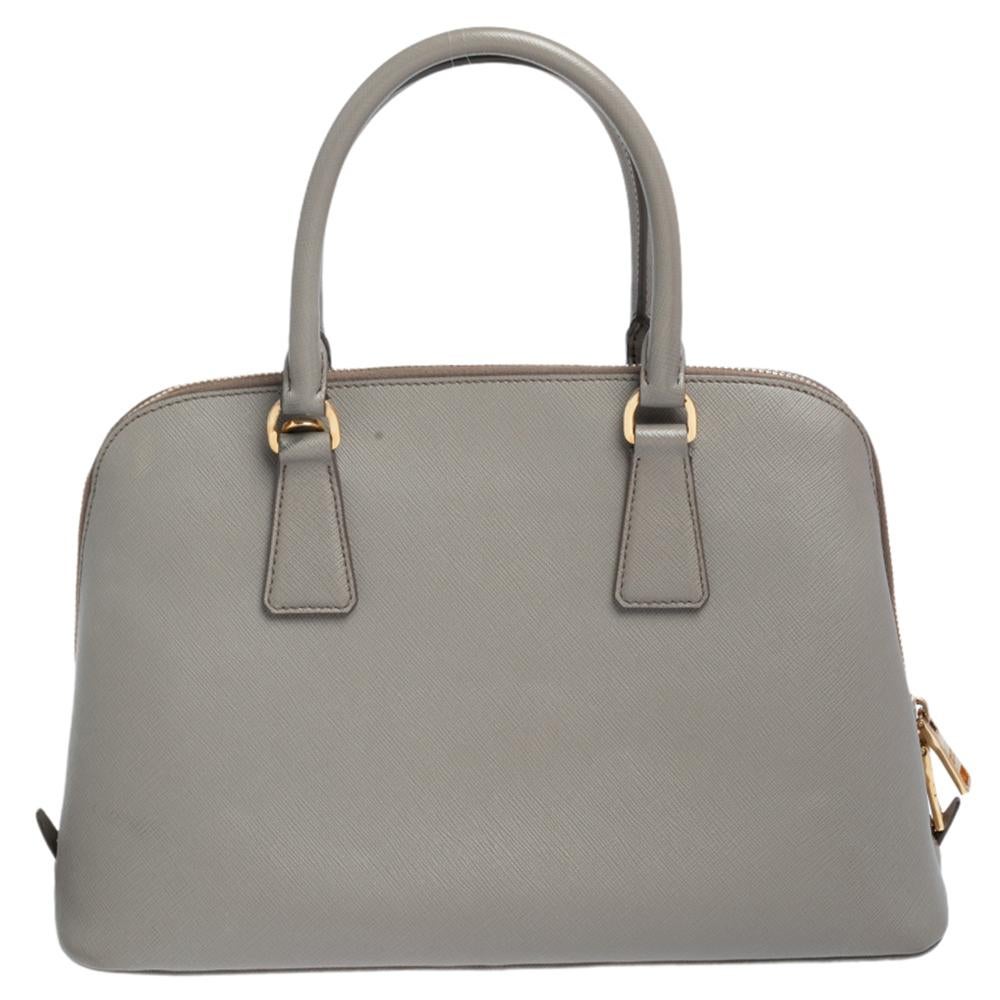 This stunning Promenade satchel is high in appeal and style. Dazzling in a classy grey shade, the bag is crafted from leather and features two rolled handles. The zip closure leads way to a fabric interior with enough space for your essentials and