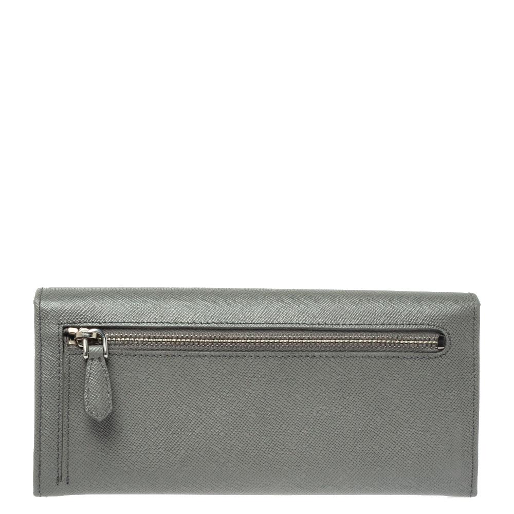 Basic essentials can be carried effortlessly in this grey-hued Prada Continental wallet. Crafted from Saffiano Lux leather, the flap style wallet features the brand detail on a bow at the front and inside, it has multiple card slots, open