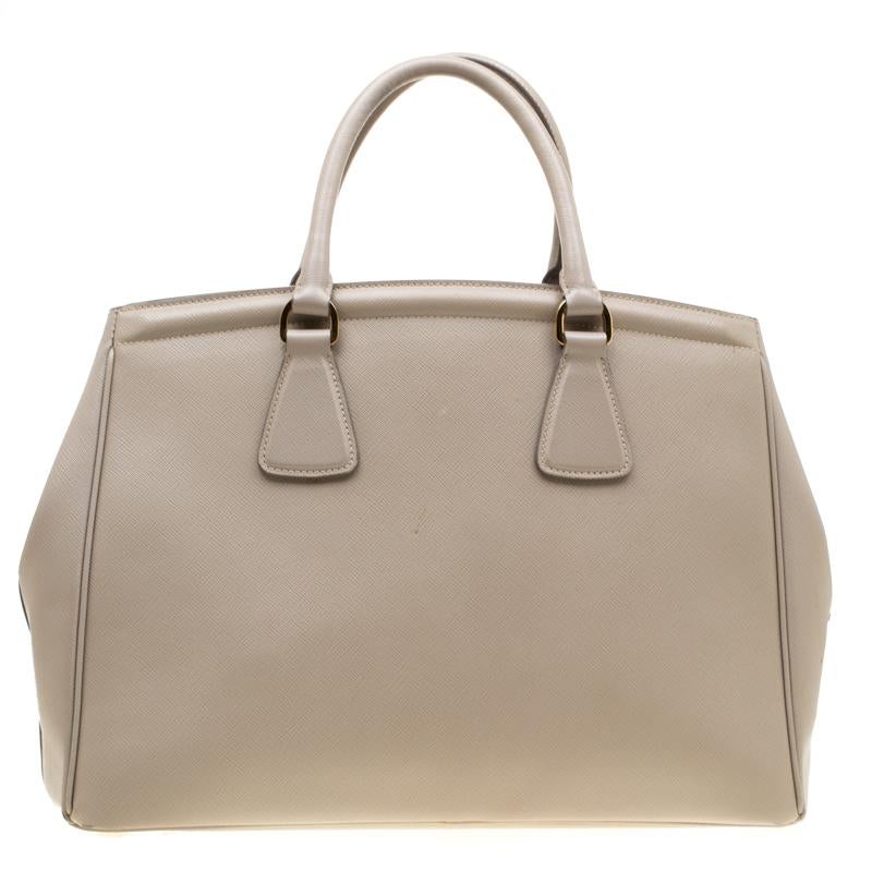 Masterfully created, this Prada tote is a style icon. Designed in a leather body, it exudes style, class and dignity in equal measures. This delightful grey piece is held by two top handles and equipped with a spacious nylon interior.

Includes: The