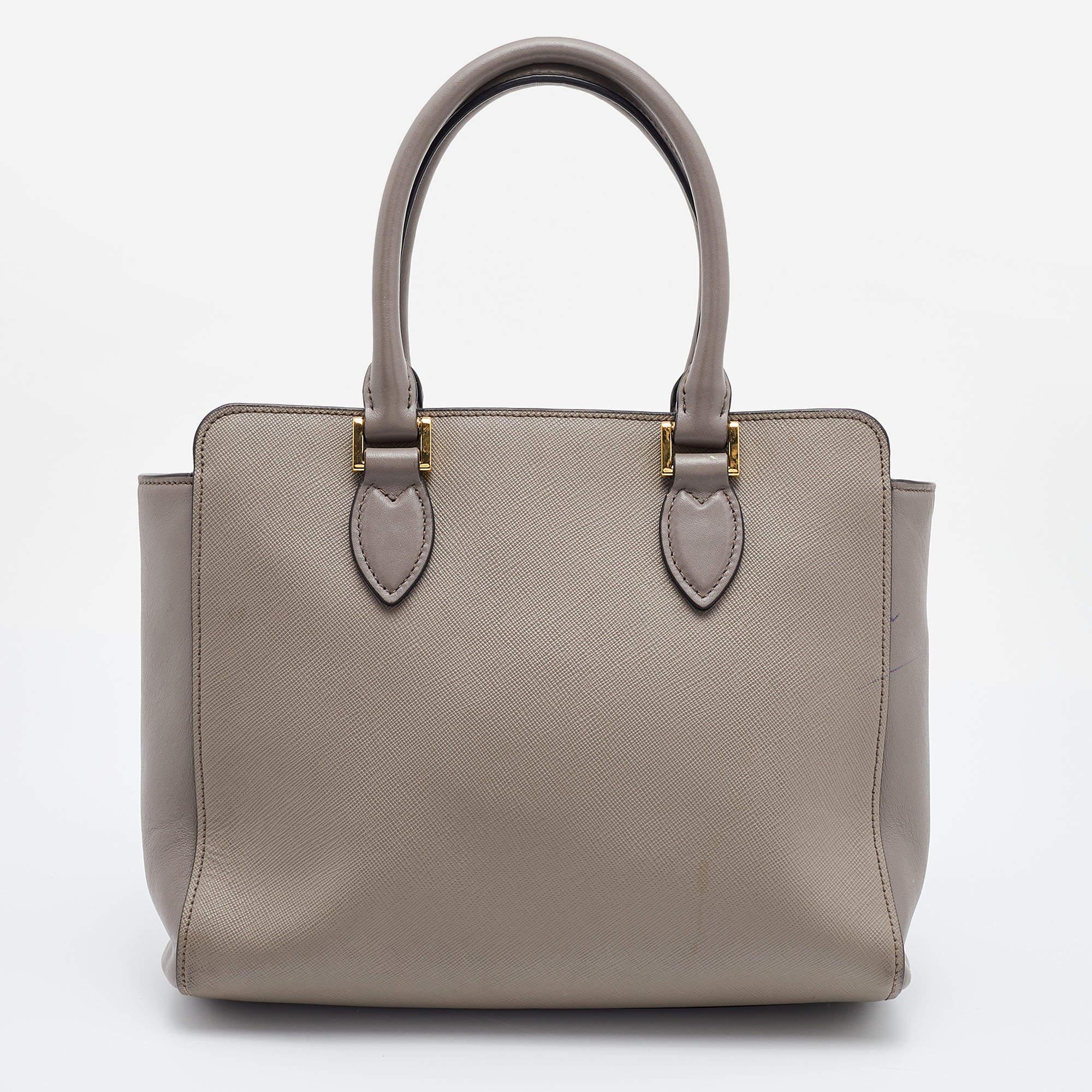 Striking a beautiful balance between essentiality and opulence, this tote from the House of Prada ensures that your handbag requirements are taken care of. It is equipped with practical features for all-day ease.

Includes: Detachable Strap
