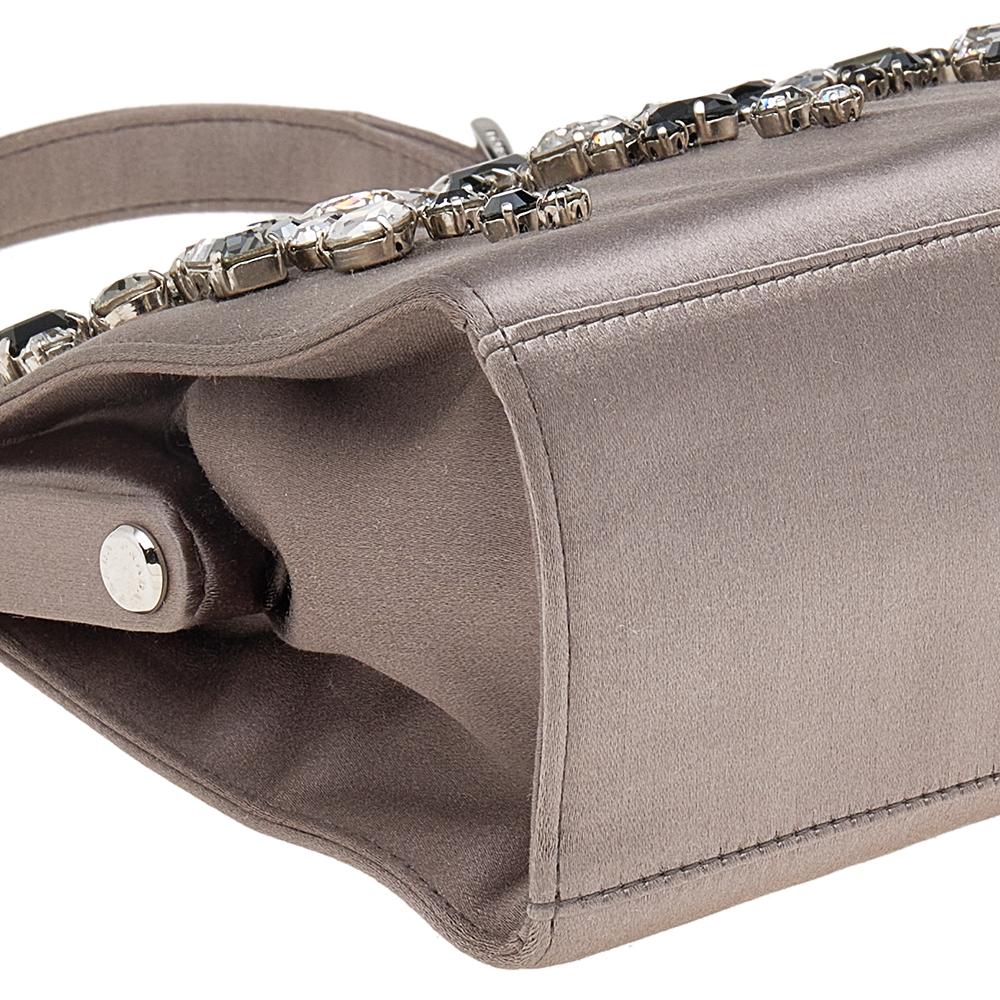 A structured and compact bag can assist you with many outings and can be styled with most of your special attires. Prada's bag is an example of the label’s penchant for creating staple pieces. It is crafted from satin in a grey shade and features a