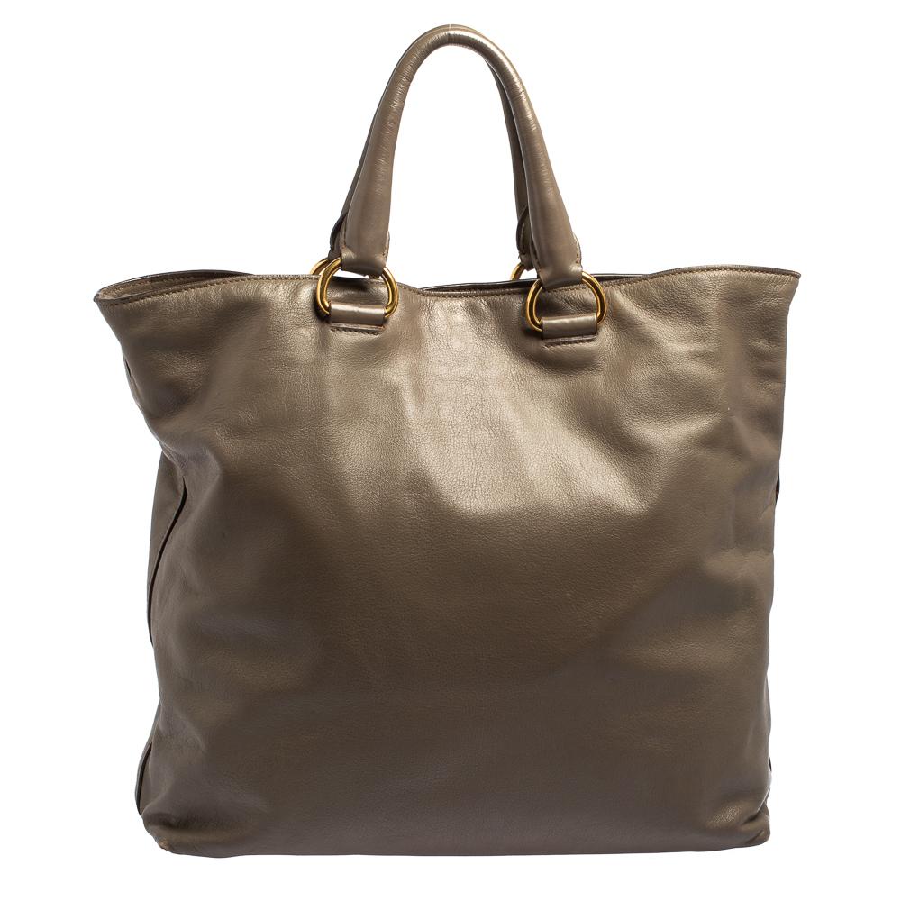 This shopper tote from Prada is a creation meant to assist you with style and ease. It comes crafted from soft calf leather and gold-tone hardware. The label is flaunted on the front, two handles are provided for you to carry it and a spacious