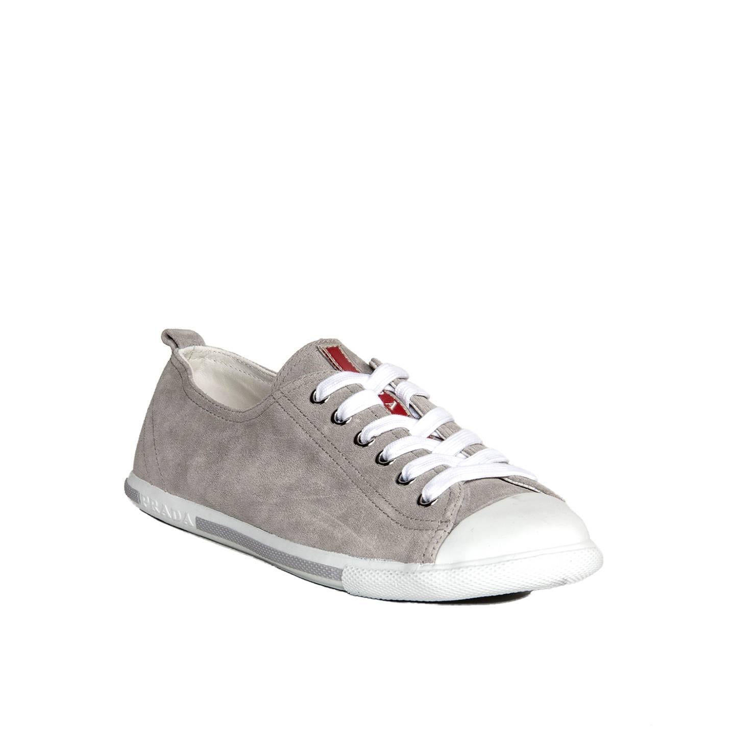 Prada Sport grey suede sneakers for women with white laces, white rubber cap toe and base, which is also enriched by a white Prada logo and a grey band. A red and silver Prada logo embellishes the tongue, the sole and the inner sole.

Size  40