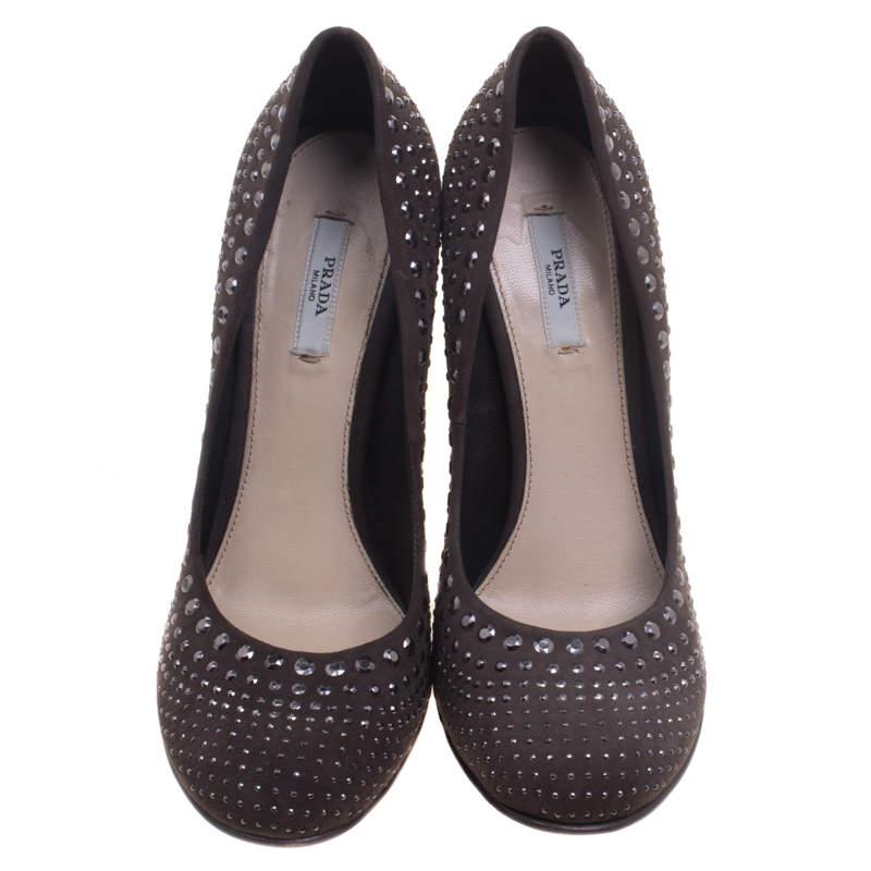 Go classy with these pumps from Prada. Crafted from grey suede, they are covered with pretty stud details. They also feature a round toe, block heel and leather-lined interior with the brand's label. The pumps are so stylish, even the heels have the