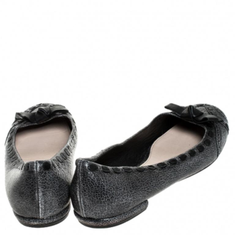 Ces chaussures plates grises de Prada sont minimalement élégantes, conçues juste pour la fashionista en vous. Les chaussures plates en cuir sont dotées d'un nœud et offrent une bonne tenue. Restez à l'aise tout au long de la journée avec ces