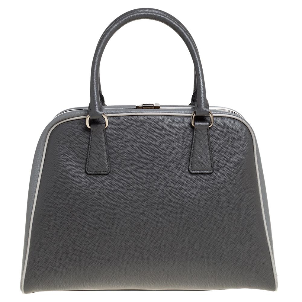 Giving handle bags an elegant update, this Pyramid Frame bag by Prada will be a valuable addition to your closet. It has been crafted from leather and styled with silver-tone hardware. It comes with dual top handles, protective metal feet at the