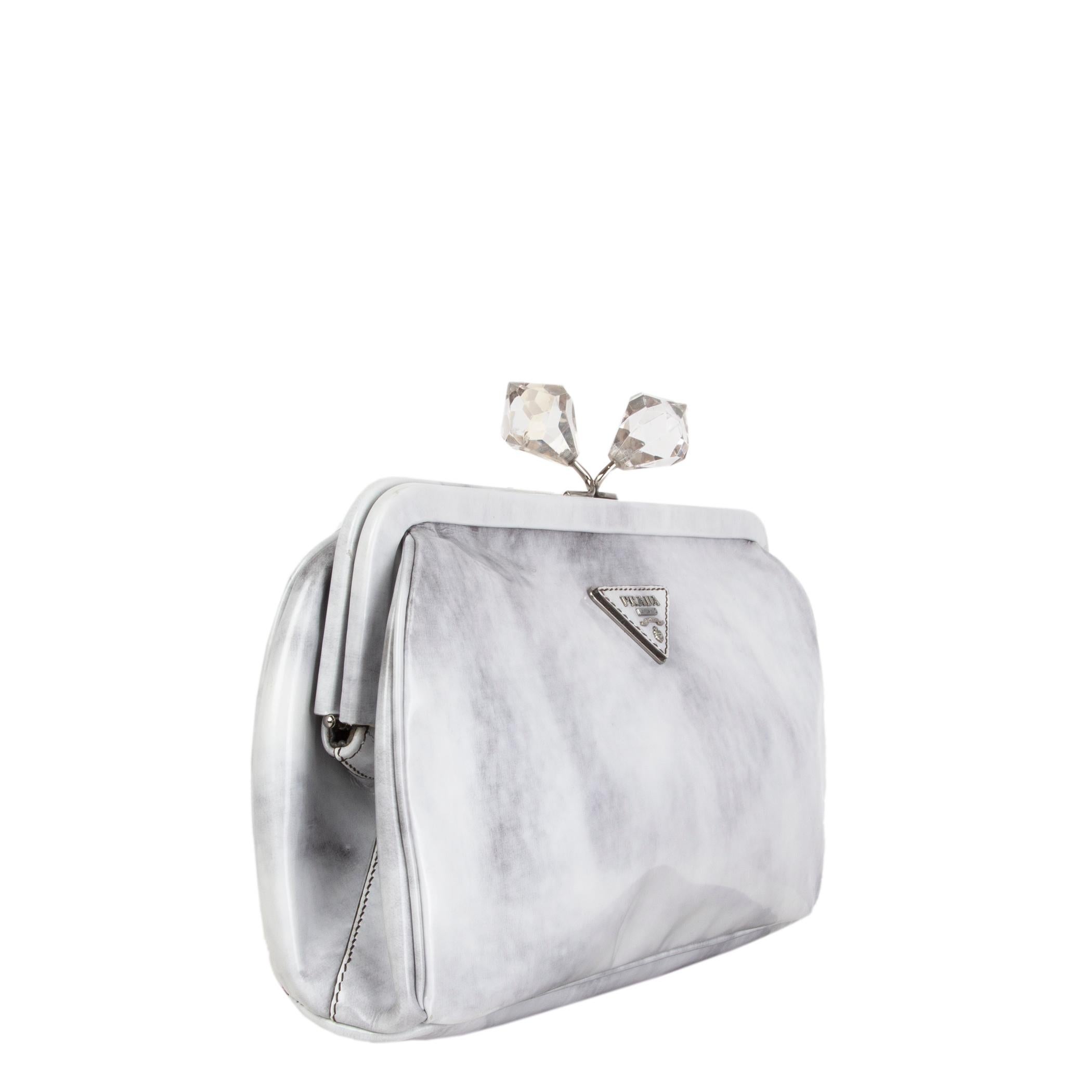 Prada frame clutch in Grigio (light and dark grey) Spazzolato leather. Closes with a crystal embelllished kiss-lock on top. Lined in dark grey leather with an open pocket against the front and a zipper pocket against the back. Has been carried and