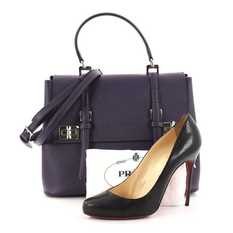 This authentic Prada Half Flap Double Turn Lock Satchel Saffiano Leather Large is a perfect companion for daily excursions. Crafted from purple saffiano leather, this functional bag features half flap with buckled straps, side snap buttons, double