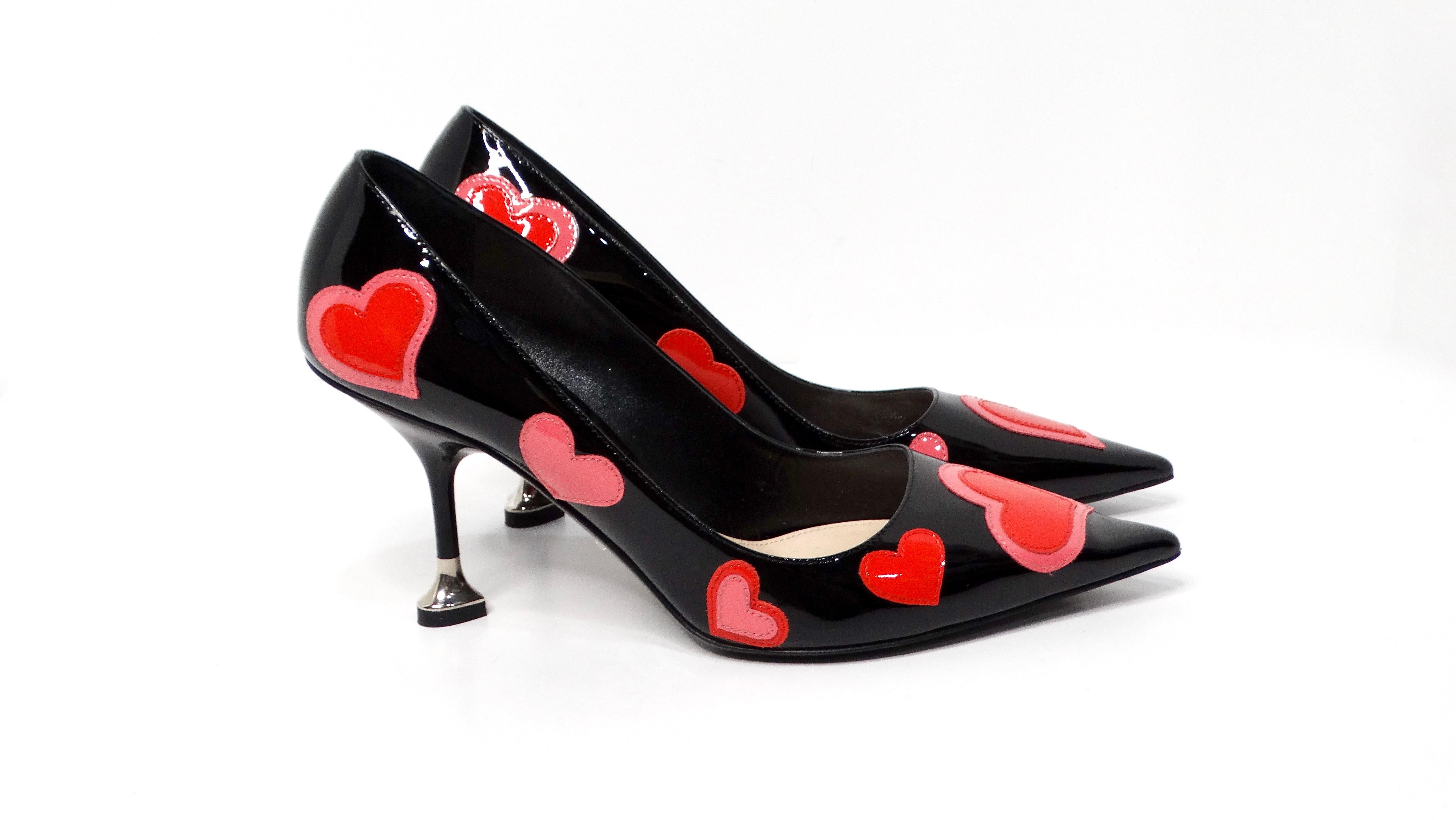 Step into the spotlight with Prada's Heart Print Patent Leather Pumps, a stunning blend of playful elegance and high-fashion sophistication. Crafted entirely from glossy patent leather, these pumps feature a chic black base adorned with a delightful