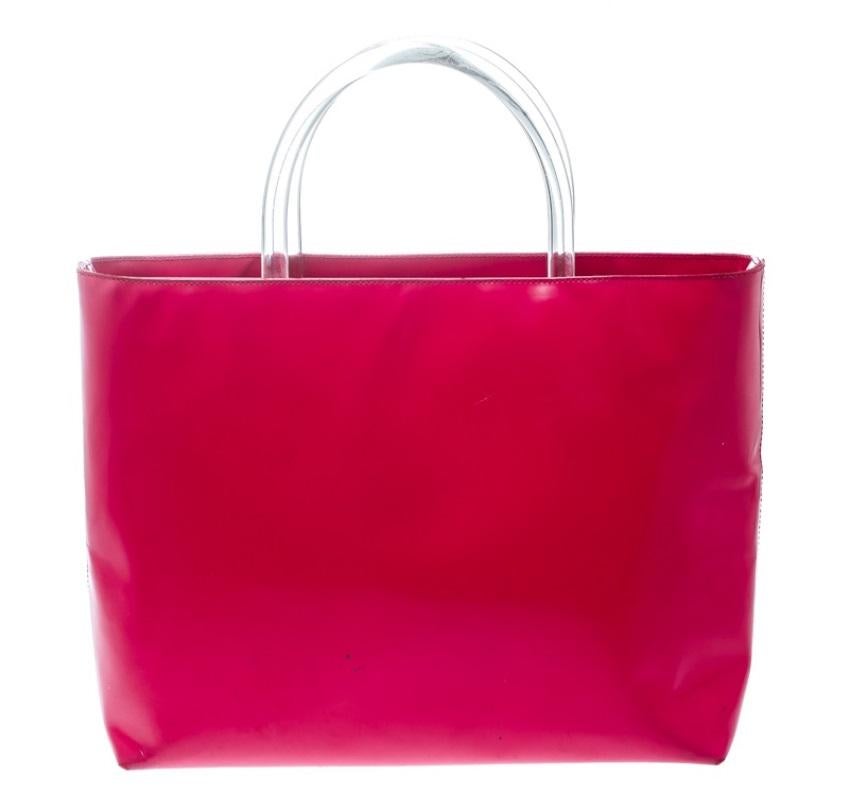 Bags as pretty as this one by Prada are not creations you find every day. That's why this bag is worthy of a place in your closet. It has been crafted from pink patent leather and equipped with a spacious nylon interior and two clear plastic