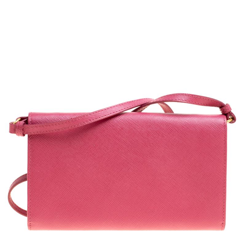 Astoundingly beautiful is this lovely clutch bag from Prada. Raising the temperatures in hot pink, this bag is crafted from saffiano leather and features an elegant silhouette. It flaunts a front flap closure with gold tone detailing and an