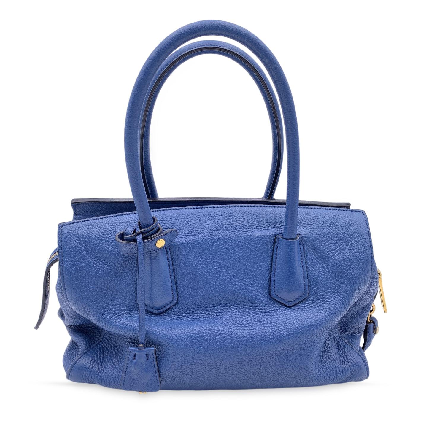 This beautiful Bag will come with a Certificate of Authenticity provided by Entrupy. The certificate will be provided at no further cost

Prada tote bag crafted out of pebbled leather in blue color (Prada official color is 'Inchiostro'). Gold metal