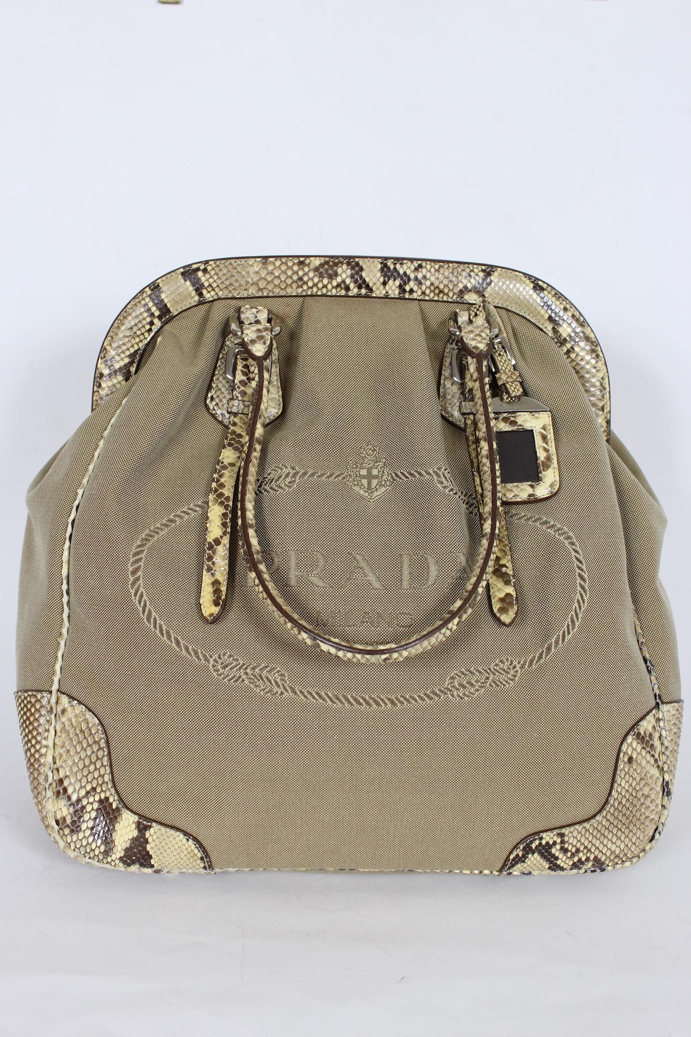 This chic and stylish Prada bag is the perfect accessory for any fashion-forward individual. The tote bag is expertly crafted from a combination of premium beige canvas and luxurious leather, giving it a unique and sophisticated look. The bag