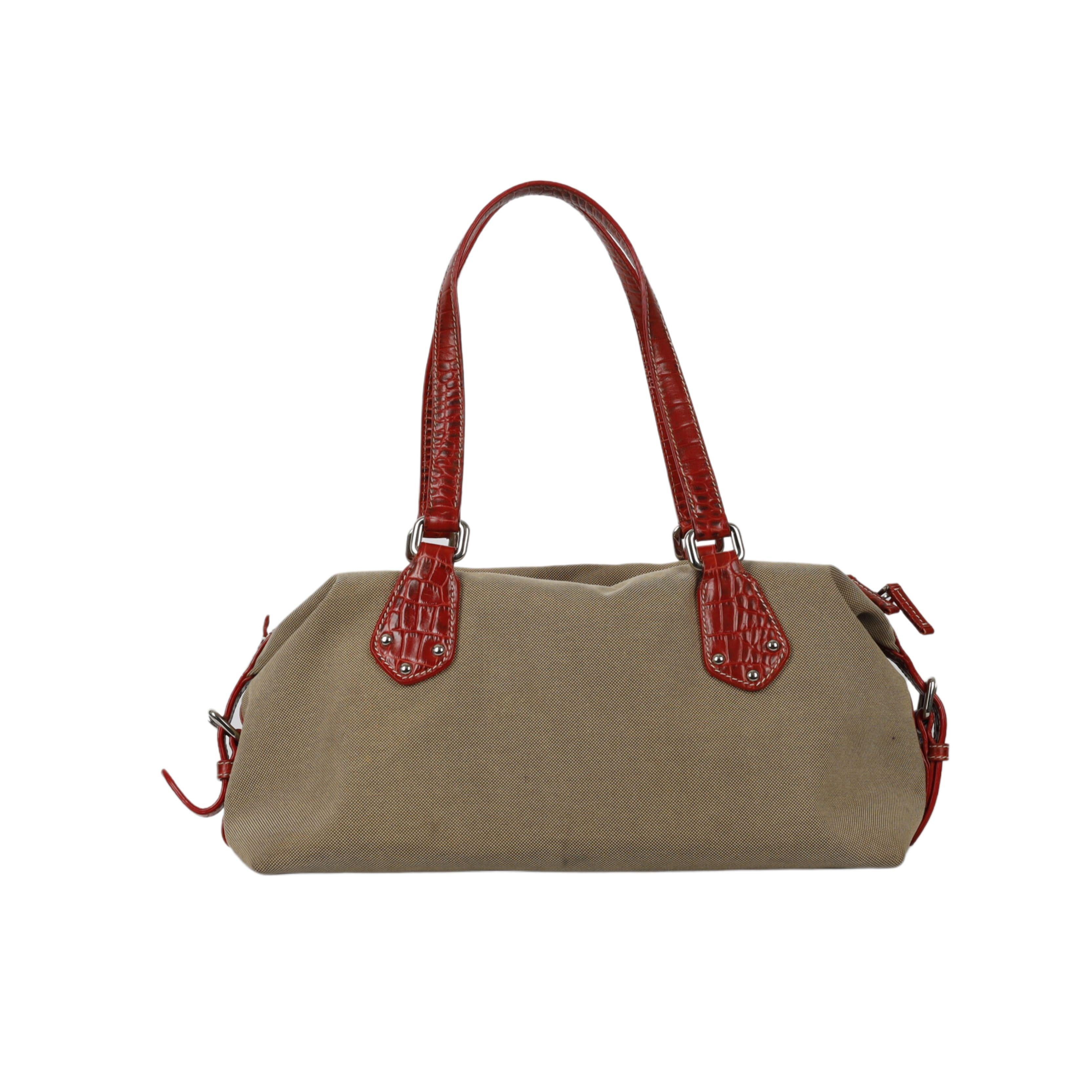 This luxe Jacquard Bowling Handbag from Prada exudes sophistication and style. Crafted with high-quality canvas in beige and exotic leather trims in red, it offers a classic silhouette along with two top handles. Inside, it provides plenty of space