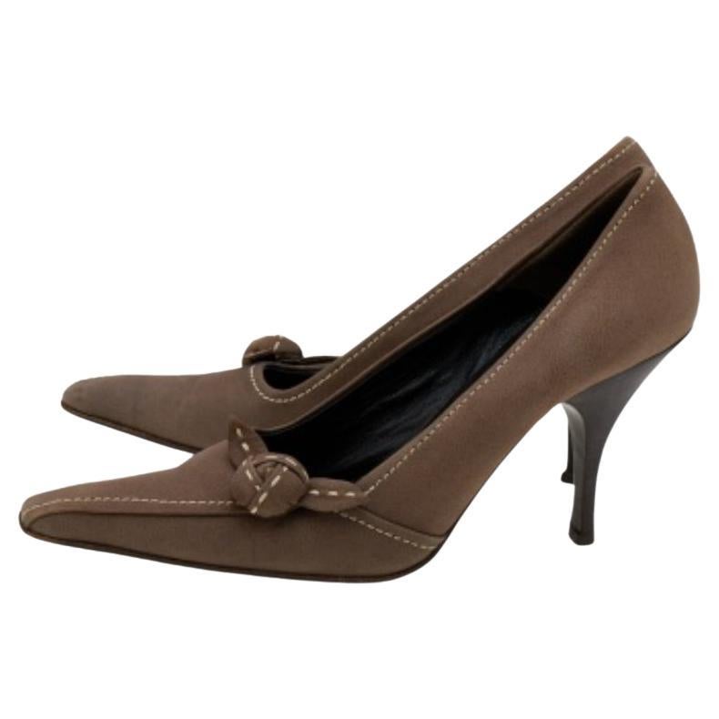 How classy are these pumps from the House of Prada! They are designed using khaki-brown leather, which is augmented with stitch detailing and a knot on the front. They showcase a slip-on feature and slim heels. Make a fashion statement as you walk