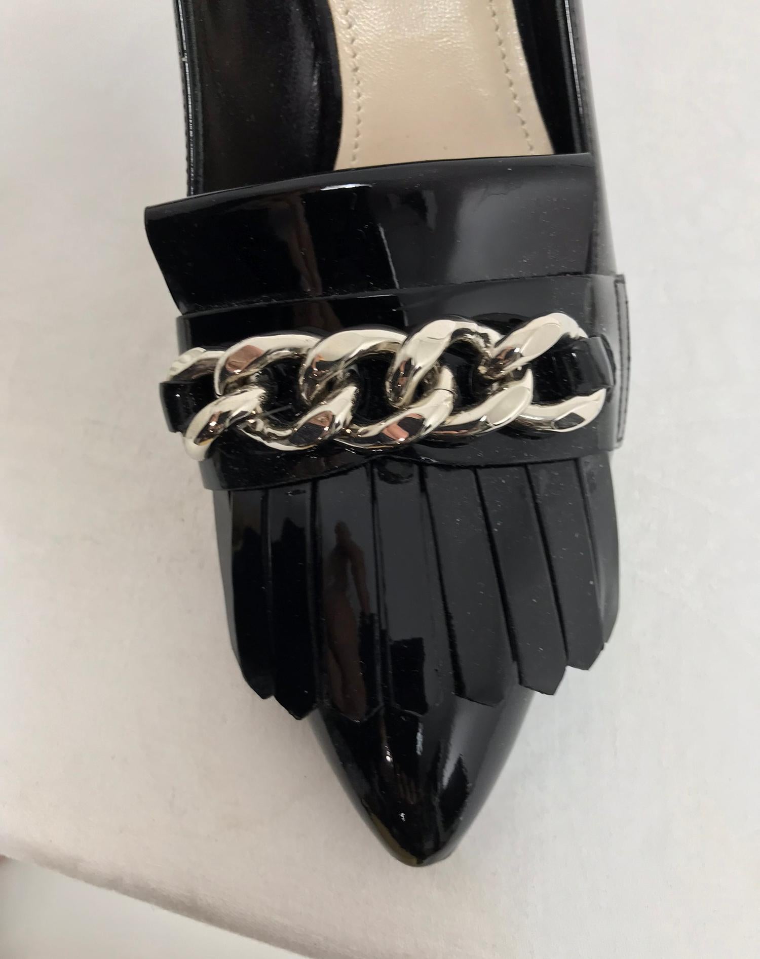 Prada Kiltie Chain Pumps in black patent leather 38M.  Crafted of black patent leather, Prada's pointed toe pumps are detailed at vamp with kiltie and silvertone curb-chain strap. 3.25