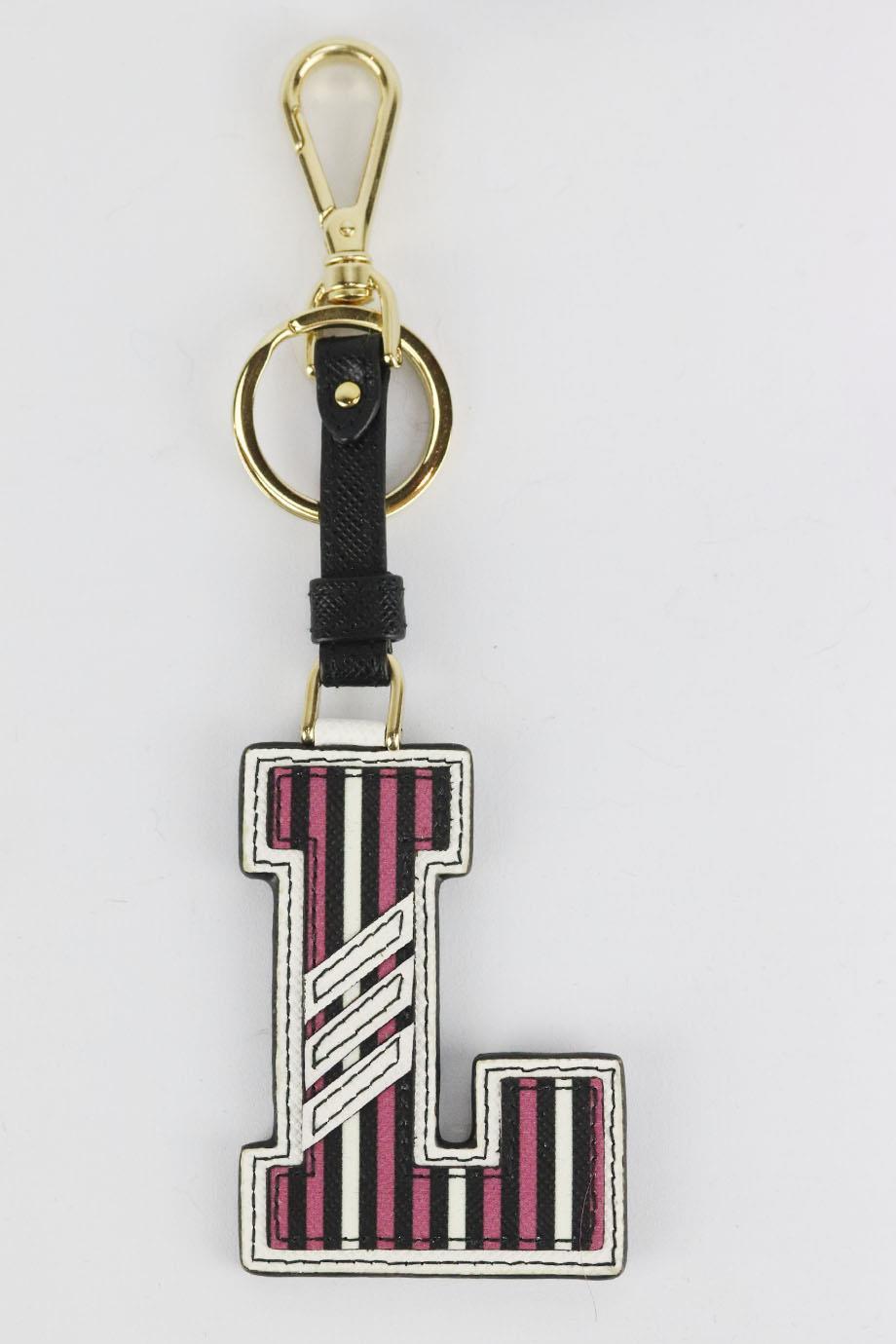 Prada 'L' initial printed textured leather bag charm. Pink, white and black. Lobster clasp fastening at top. Does not come with dustbag or box. Height: 7 in. Width: 2.1 in
