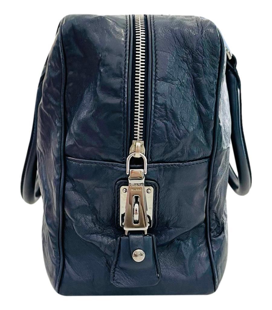 Prada Leather Bauletto Bag

Navy/grey handbag crafted in nappa leather with wrinkled effect.

Designed with branded, silver hardware and 'Prada' logo lettering to the front.

Featuring dual top handle and zipped top leading to spacious nude leather