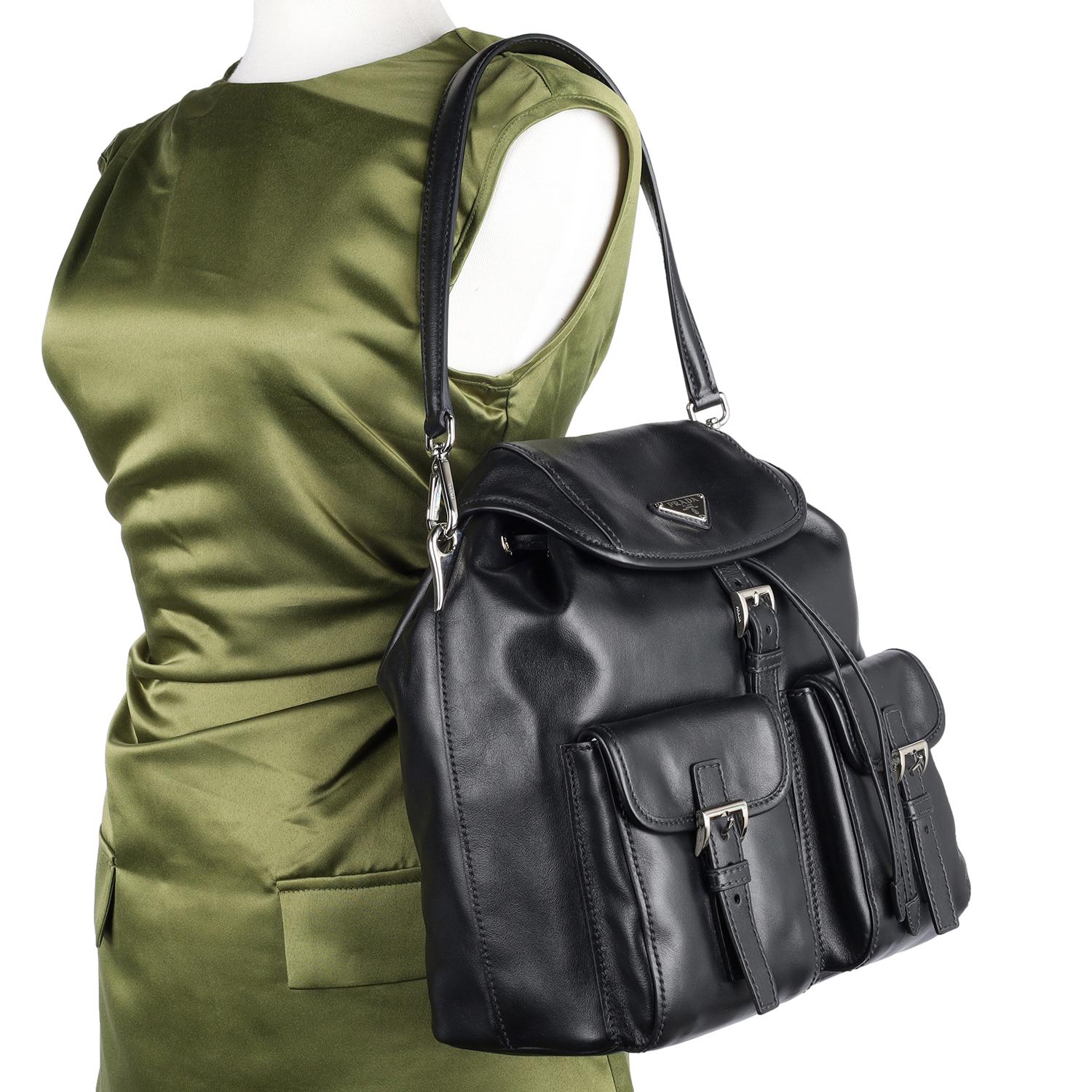 Authentic Prada Leather Double Pocket Drawstring Shoulder Bag in black leather. Known for its sleek design and practicality the bag features black leather, Prada decal on the front of the bag, a looping leather shoulder strap with silver hardware,