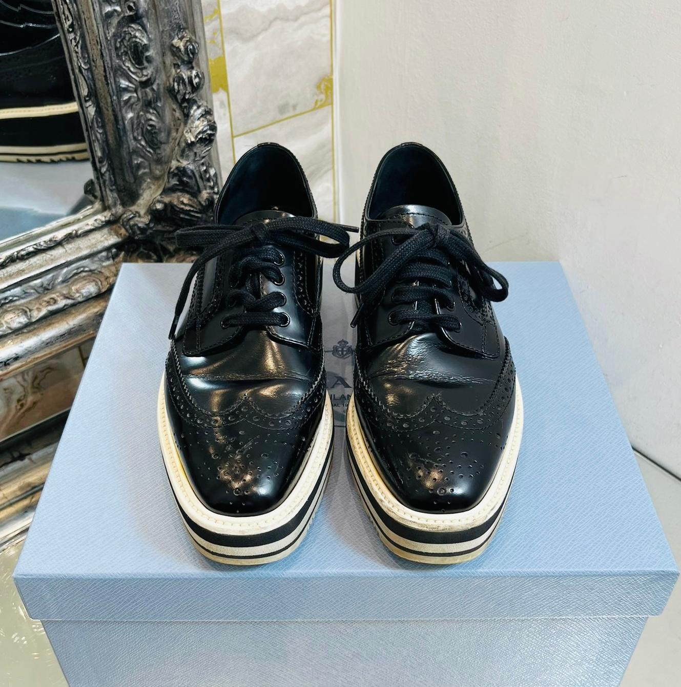 Prada Leather Platform Brogues

Black, lace-up brogues designed with wingtip detailing throughout.

Featuring almond toe and striped black & white platform.

Leather lining and insoles. Rrp £980.

Size – 35

Condition – Good (Scratches to the