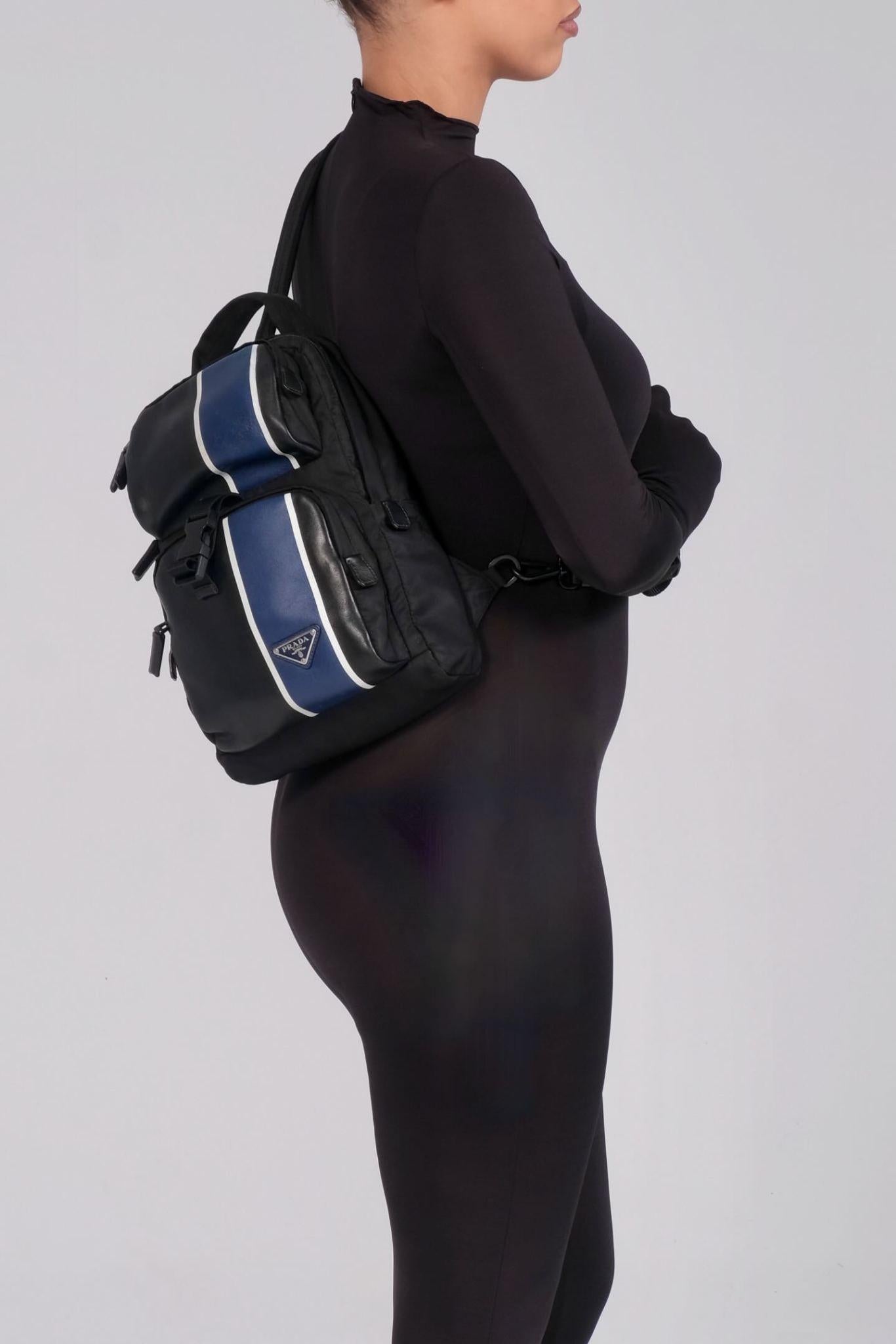 This backpack is crafted of black leather and features adjustable nylon shoulder straps, zip closure, a nylon cinch cord and a matching black Prada monogram jacquard fabric interior with a zipper pocket.

Color: black with navy
Material:
