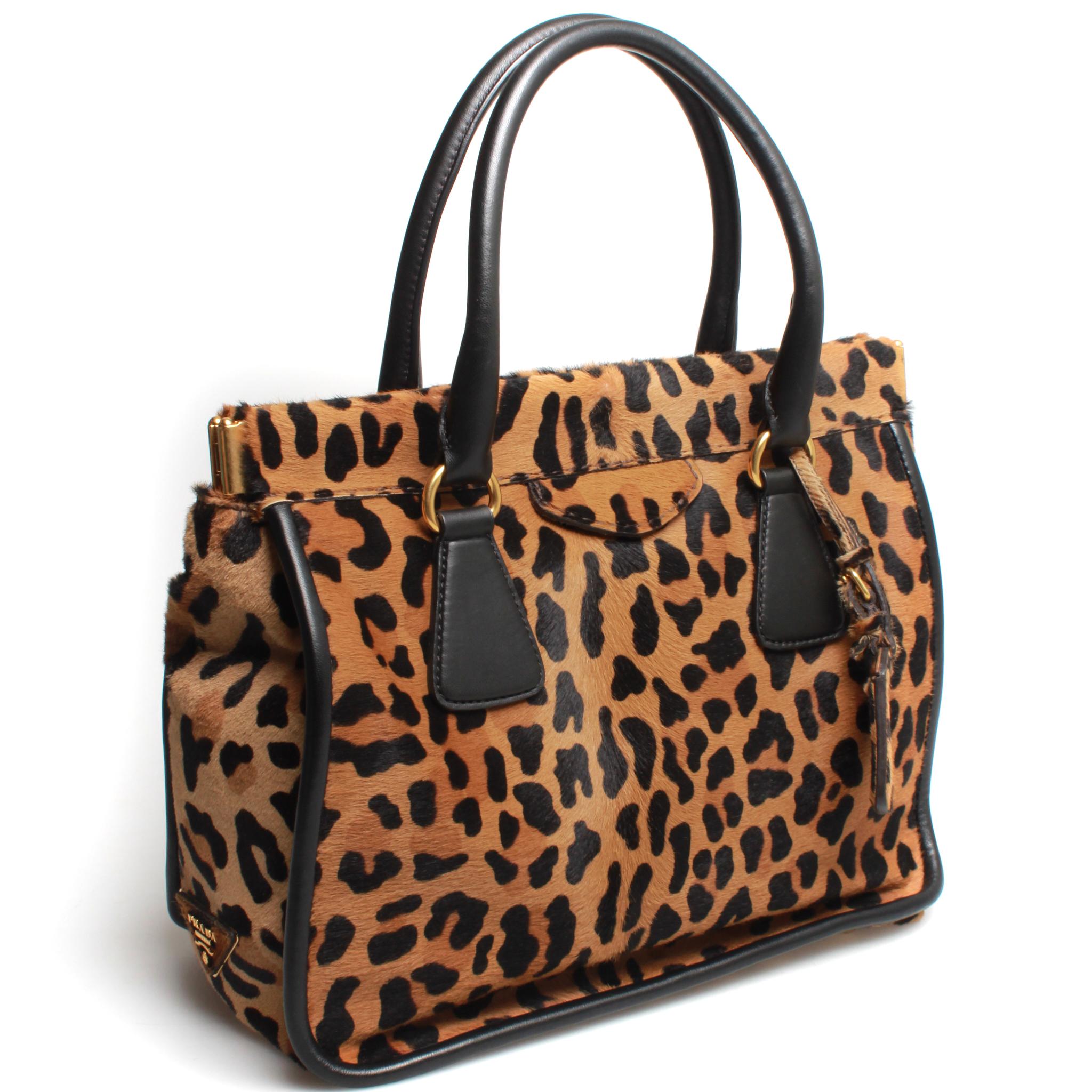 Beautifully structured leopard print PRADA pony hair handbag with gorgeous beige suede interior and dual top handles in black leather. 
Comes with original box. 
FINAL SALE
