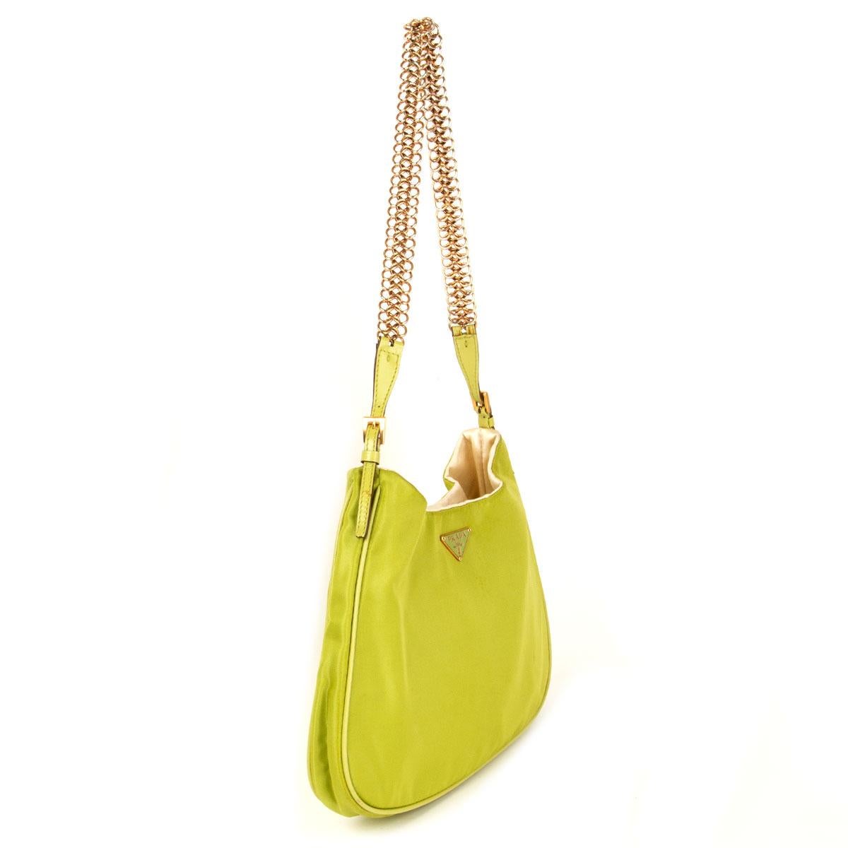 100% authentic Prada iconic mini shoulder bag in lime green nylon comes with a leather trim. Features a metal logo in gold and lime, adjustable golden chain strap with slight sign of discoloration. Lined in champagne color fabric with 3 tiny pink