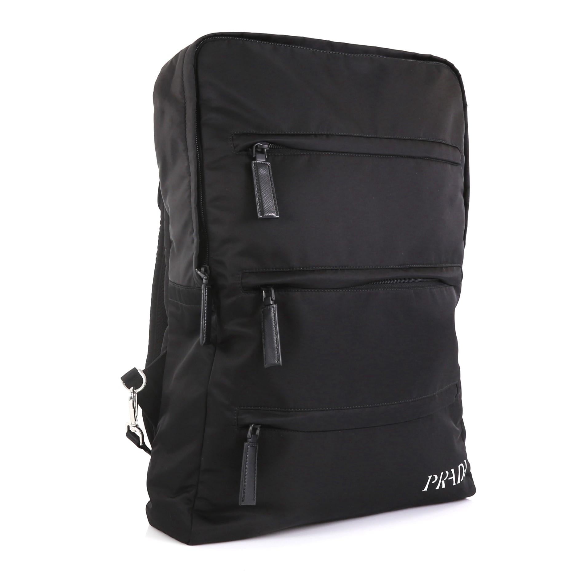 This Prada Limited Edition Rem Koolhaas Backpack Tessuto Large, crafted from black tessuto, features adjustable backpack straps, exterior front zip pockets and silver-tone hardware. Its top zip closure opens to a white nylon interior with slip