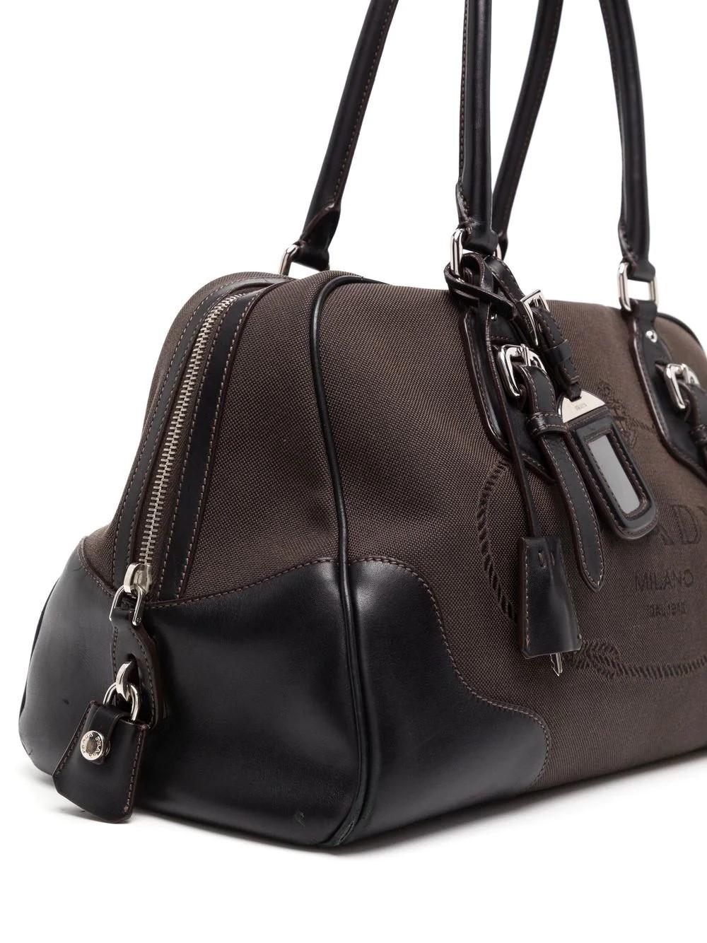 A superb Prada bowling handbag in brown leather and canvas, hardware in silver metal, and double handle in brown leather allowing the bag to be worn in the hand or on the shoulder. This bag also features the signature Prada Milano logo at the