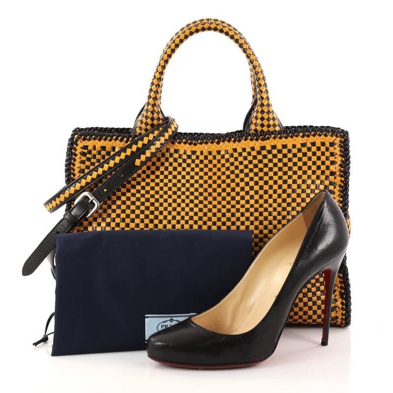 This authentic Prada Madras Convertible Open Tote Woven Leather Small is a stylish and functional bag perfect for your daily excursions. Crafted in yellow and black woven leather, this tote features dual woven handles, Prada triangle logo,