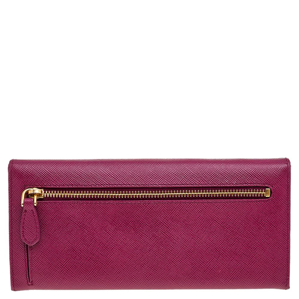 Add a pop of color to your accessories with this pretty continental wallet from Prada. Designed using magenta Saffiano leather, this wallet contains a gold-toned logo accent on the front, a zipped pocket at the back, and an organized leather-fabric