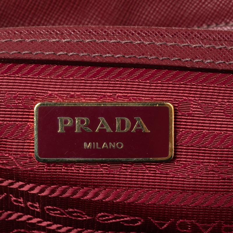 Loved for its classic appeal and functional design, the Galleria is one of the most iconic and popular bags from the house of Prada. This beauty in maroon is crafted from Saffiano lux leather and is equipped with two top handles and the brand logo