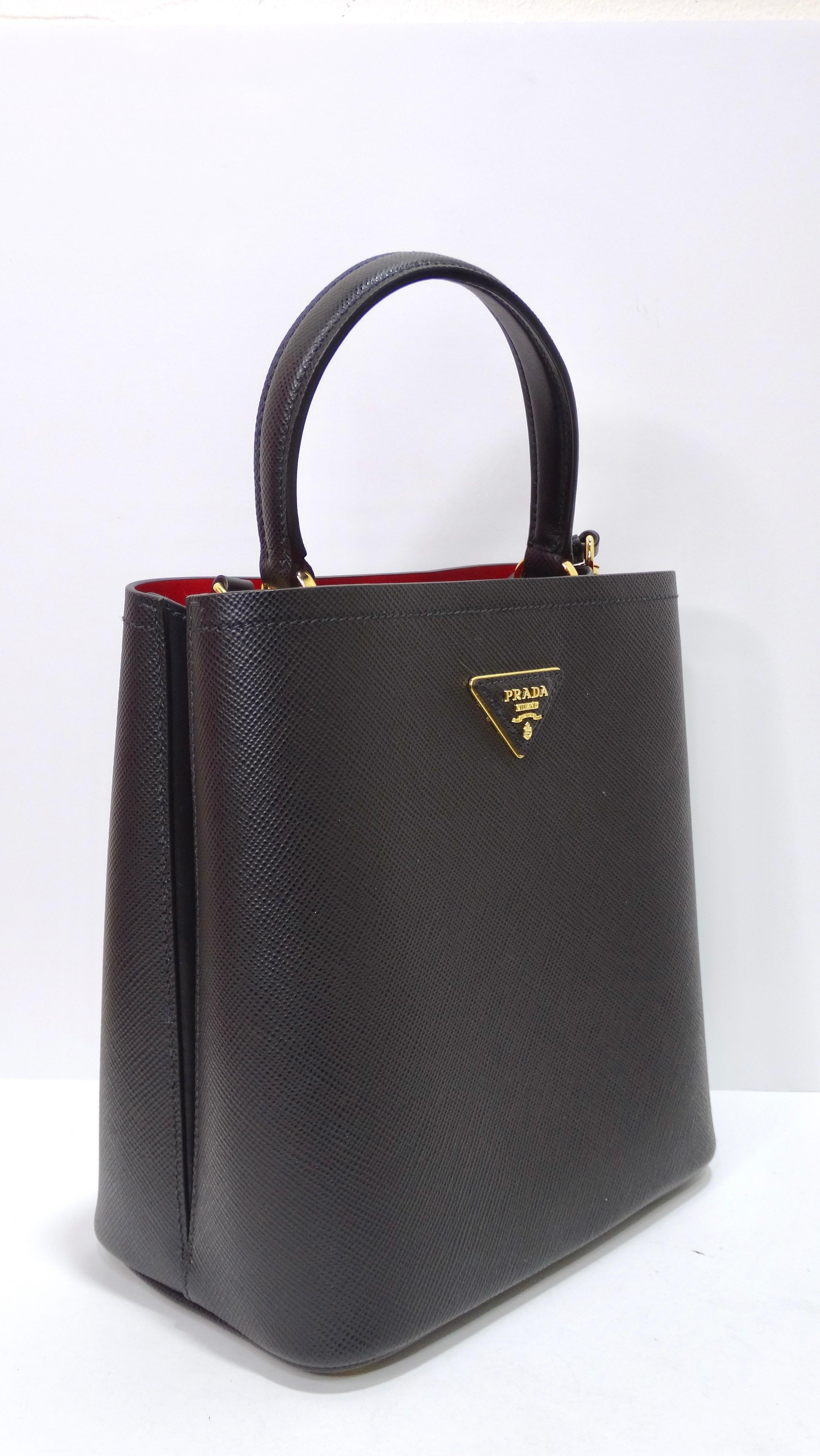 This is a sleek and essential handbag to add to your closet. Prada is known for their high quality leather goods that will never fail you. This bag features the iconic texture of Saffiano leather characterizes the compact Prada Panier bag. This is
