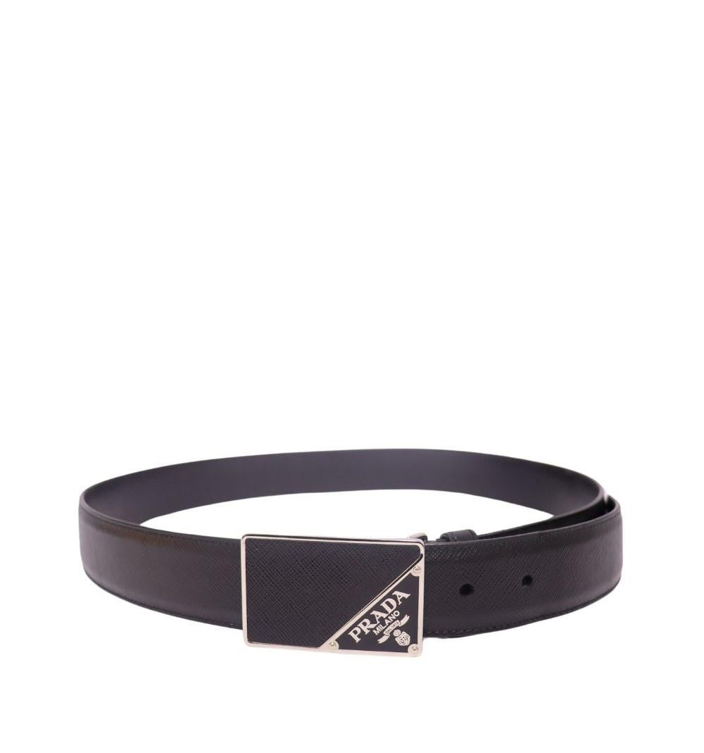 Cintura Prada da uomo in pelle saffiano, con l'iconico logo triangolare smaltato di Prada nella fibbia in metallo rivestita in pelle.

Materiale: Pelle
Larghezza: 33 mm
Hardware: Argento
Dimensioni: 90 cm
Condizioni generali: Buono
*Include un