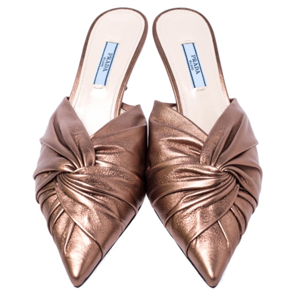 Flaunt style at its best with these beautiful mule sandals. They are crafted from metallic bronze leather and feature a twisted design at the vamps. These fashionable sandals from Prada are elevated with kitten heels. These stylish sandals will