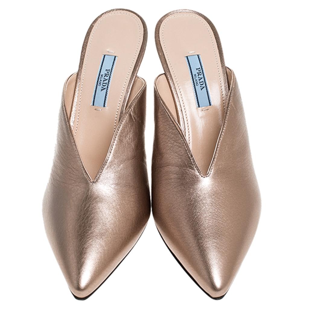 Wear these stylish mules from the house of Prada and channel your inner fashionista. Crafted from metallic bronze leather, they will elevate an outfit instantly. They feature a cone heel that perfectly complements the geometry of the mules that come