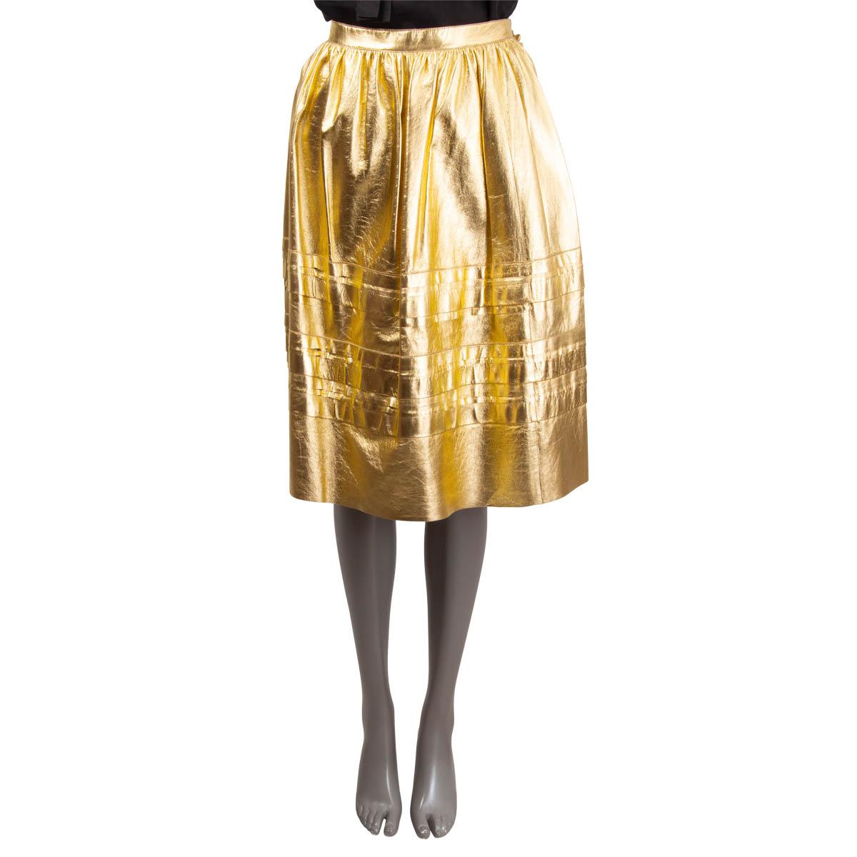100% authentic Prada layered A-line midi skirt in golden coated leather with decorative golden buttons on the side. The design features a faux buttons line on the side. The skirt opens with hook and invisible zipper on the side. Unlined. Has been