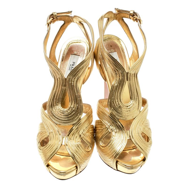 This amazing pair of metallic gold sandals is from Prada. They are crafted from leather and feature cutouts and peep toes. The platform sandals bring ankle straps with buckle fastening and 13 cm heels.

Includes: Extra Beige Tone Top Lifts, Info