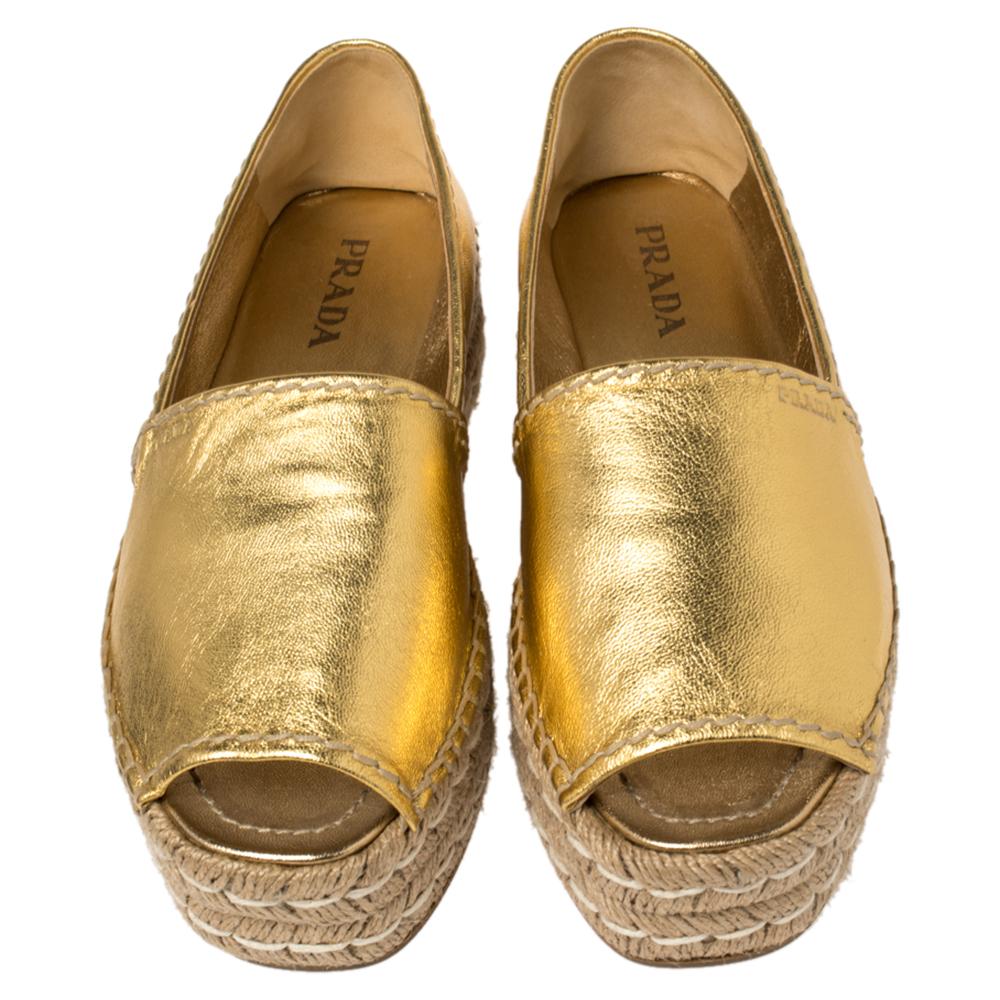 We've been amazed by the creations of Prada, time and again! These espadrilles are no different. The metallic gold leather construction comes alive with the peep-toe silhouette and braided platforms. They are complete with comfortable leather-lined