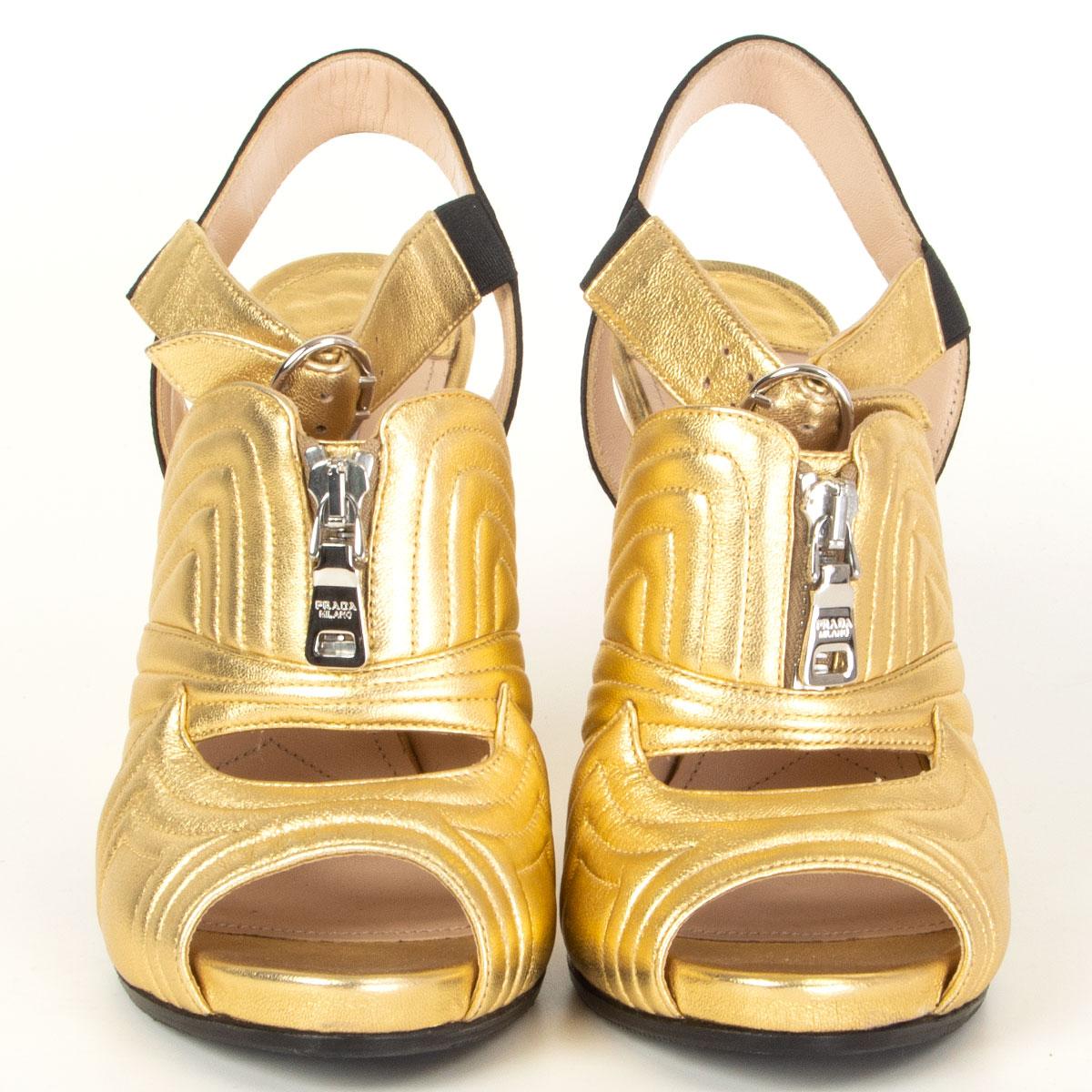 authentic Prada sandals in metallic gold-tone calfskin and black satin heel strap featuring a chunky heel and silver-tone zipper detail. Have been worn and are in excellent condition. Rubber sole has been added. 

Imprinted Size 36.5
Shoe Size
