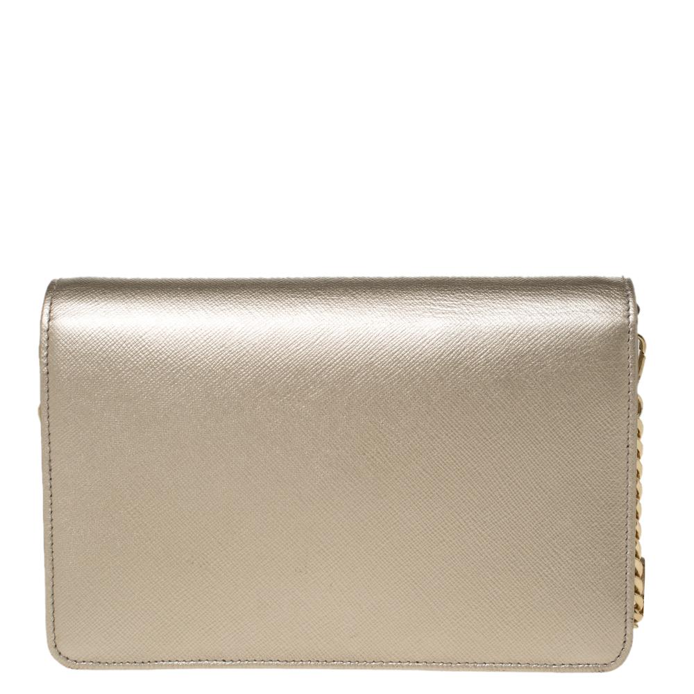 This lovely bag by Prada carries an elegant and chic design. It will be a head-turning addition to anything you wear it with. It features a front flap, a leather exterior, a chain shoulder strap, and the brand label in gold-tone hardware. Grab this
