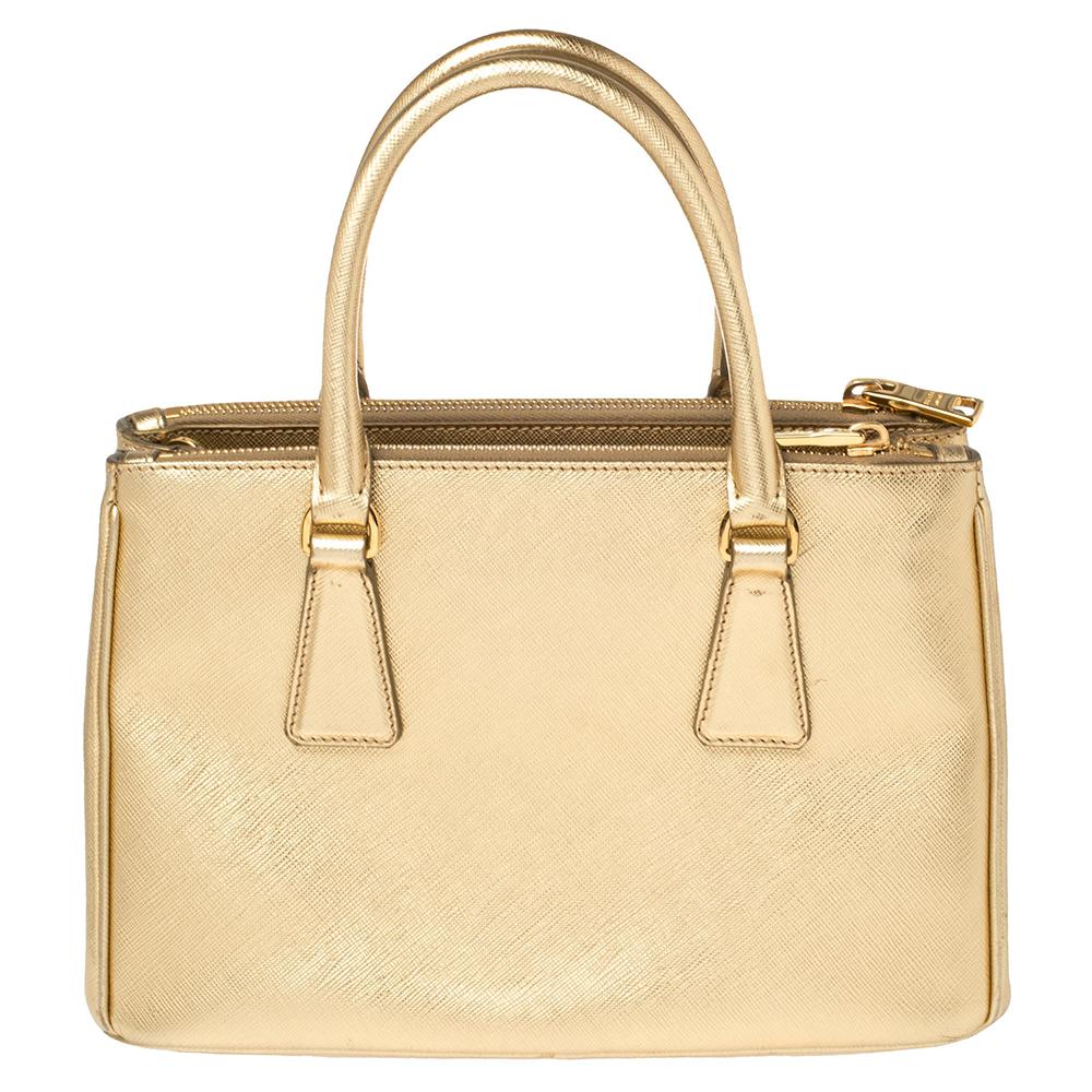 Feminin in der Form und großartig im Design, diese Double Zip-Tasche von Prada wird eine beliebte Ergänzung für Ihren Kleiderschrank sein. Sie ist aus Leder gefertigt und mit goldfarbenen Beschlägen ausgestattet. Sie verfügt über zwei Griffe an der