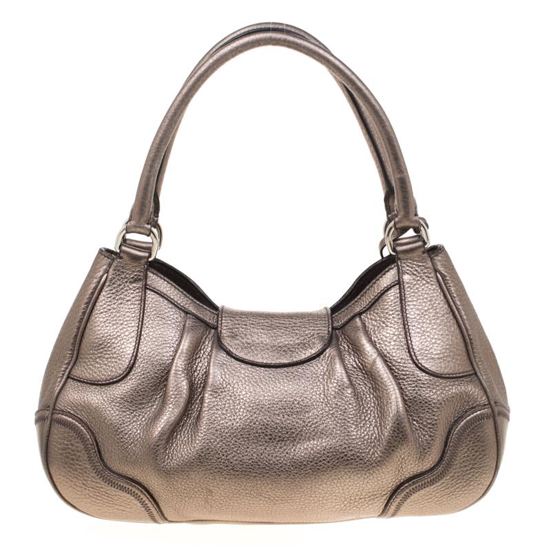 Effortlessly stylish this bag from the house of Prada is designed in metallic grey leather with a Prada embossed buckle closure. It features a top handle, a clochette and opens to a nylon-lined interior that can easily hold your