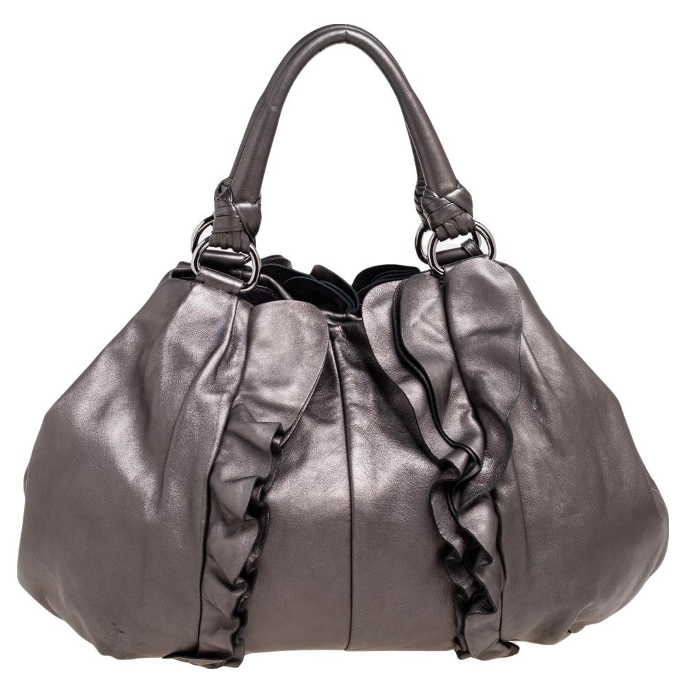 This Prada hobo for women comes fashioned with metallic grey leather. It has an exterior laid with ruffle trims and they form a fine outline. The designer bag is lined with fabric and held by a single handle.

Includes: Original Dustbag