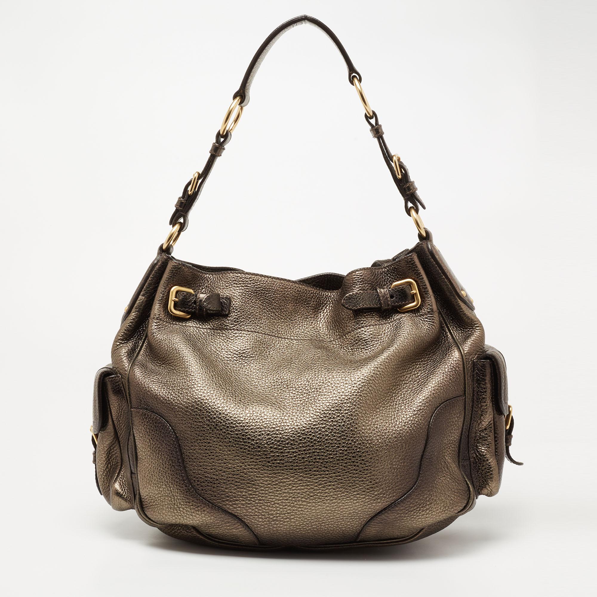 This hobo from the House of Prada is absolutely gorgeous! Made from metallic Moss Vitello Daino leather, this hobo is highlighted with gold-tone hardware and a single handle. It accommodates a roomy nylon-lined interior. Carry this hobo and flaunt a